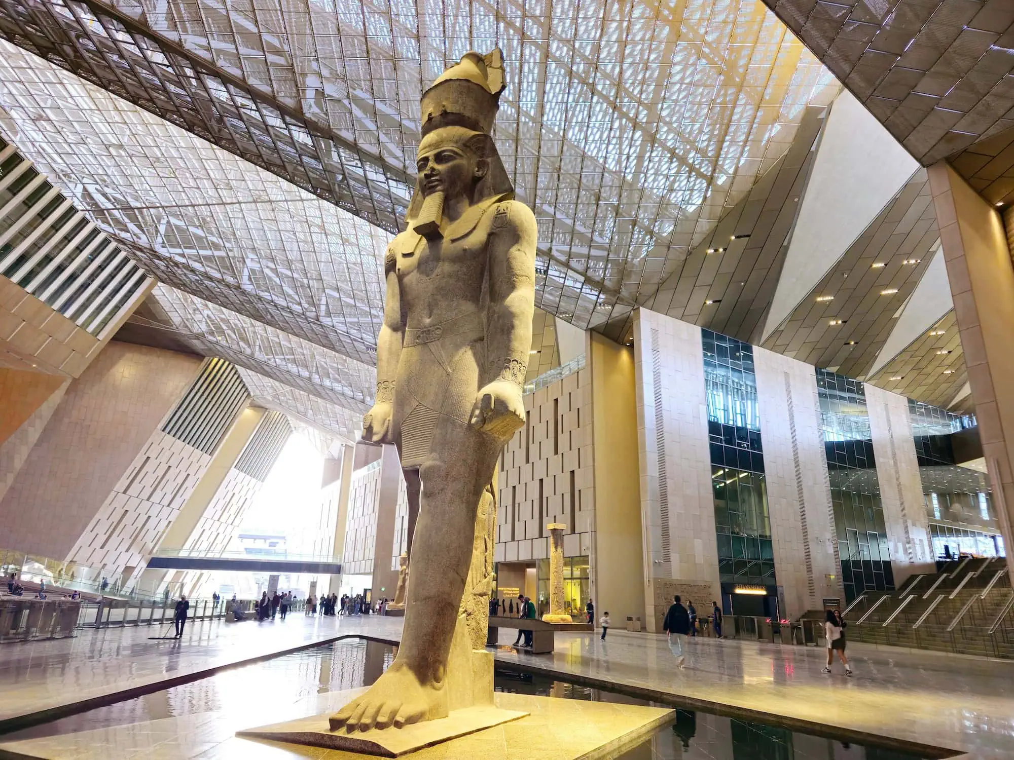 Grand Egyptian Museum interior with pharaoh statue and accessible escalators