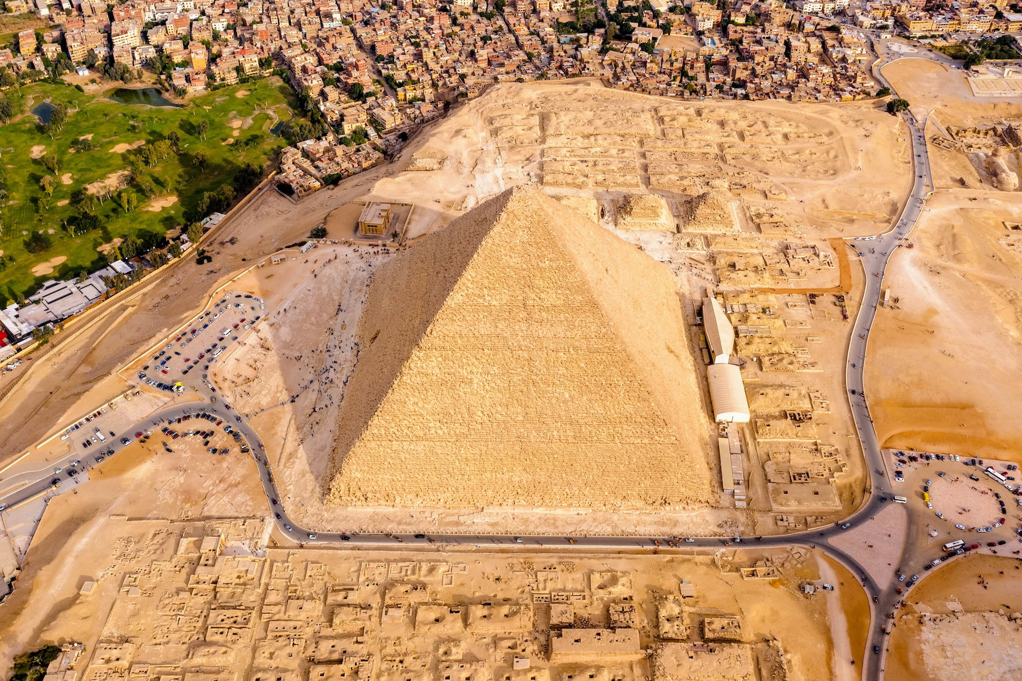 Vista aérea de las pirámides de Giza con áreas turísticas vacías y estacionamientos despejados