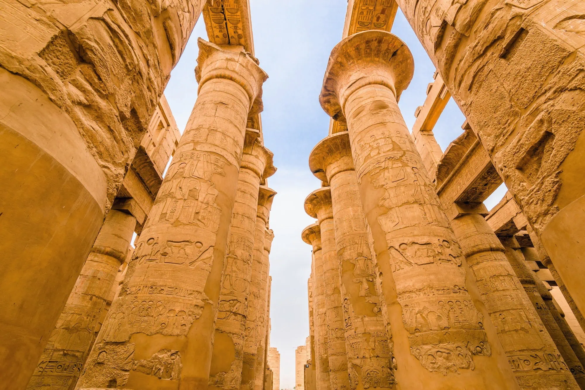 Massive ancient Egyptian columns with hieroglyphic carvings at Karnak Temple's Great Hypostyle Hall