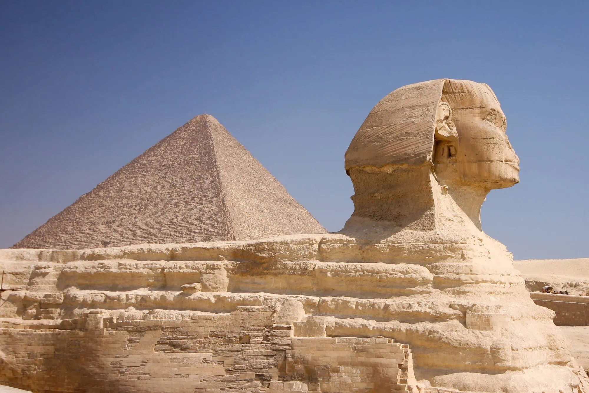 The Great Sphinx of Giza with the Great Pyramid of Khufu (Cheops) rising behind it, on the Giza Plateau outside Cairo, Egypt — the Sphinx is a 73-metre limestone monolith, the Pyramid is the only surviving Wonder of the Ancient World