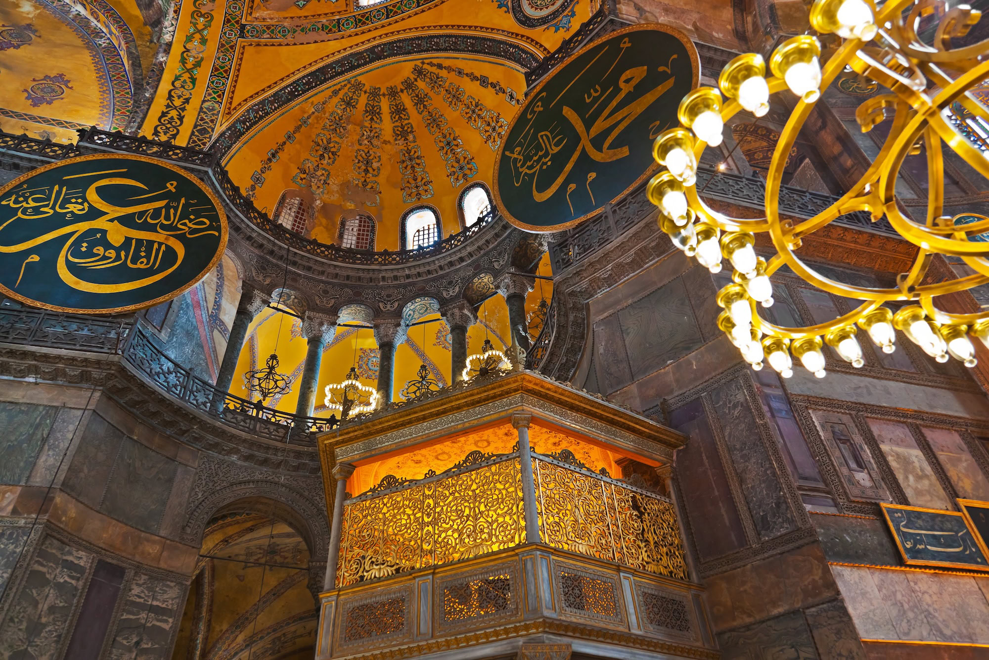 Interior of Hagia Sophia showing Islamic calligraphy, dome, and mihrab after Ottoman conversion