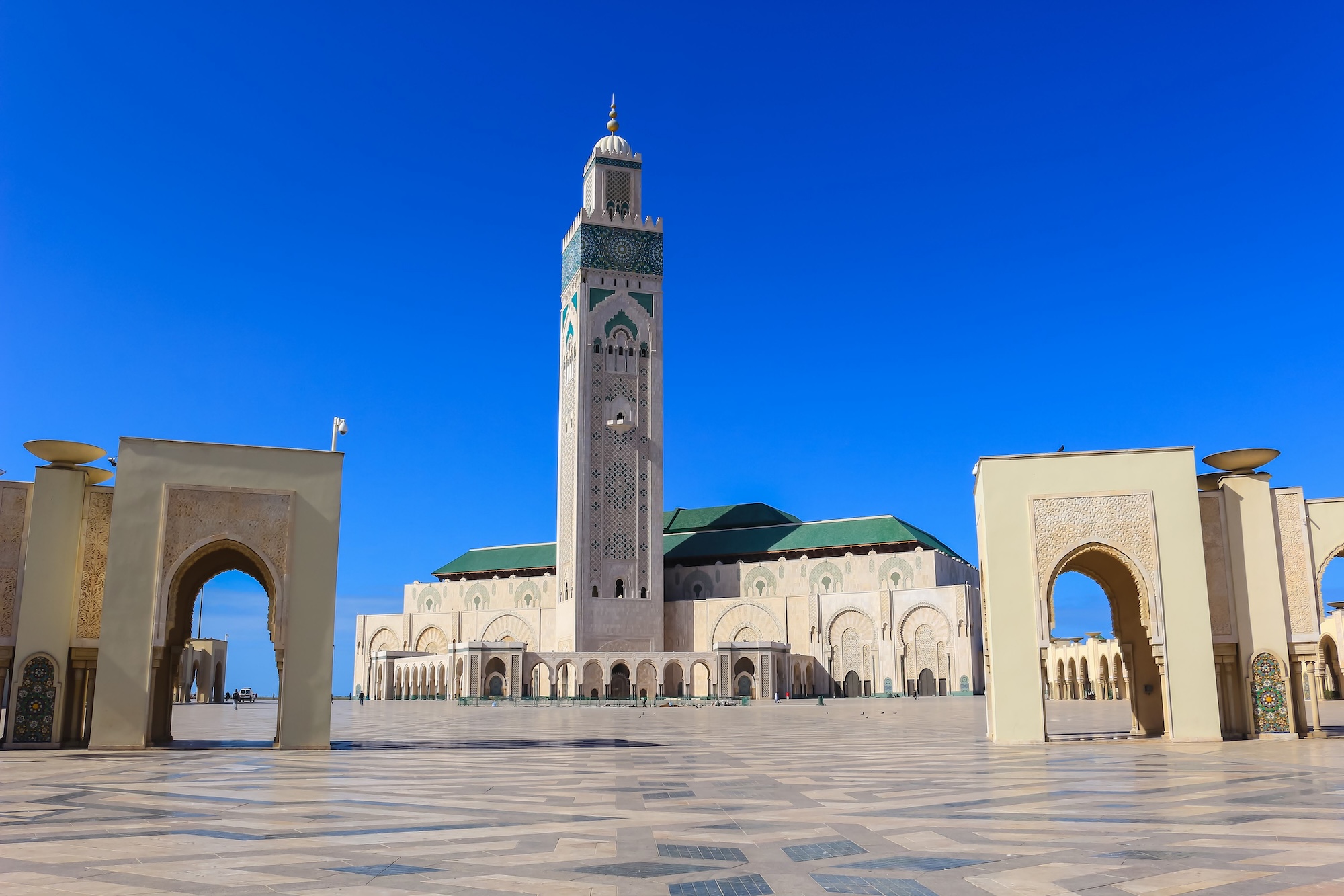 Hassan II Mosque exterior with minaret, arches, dome and marble courtyard in Casablanca