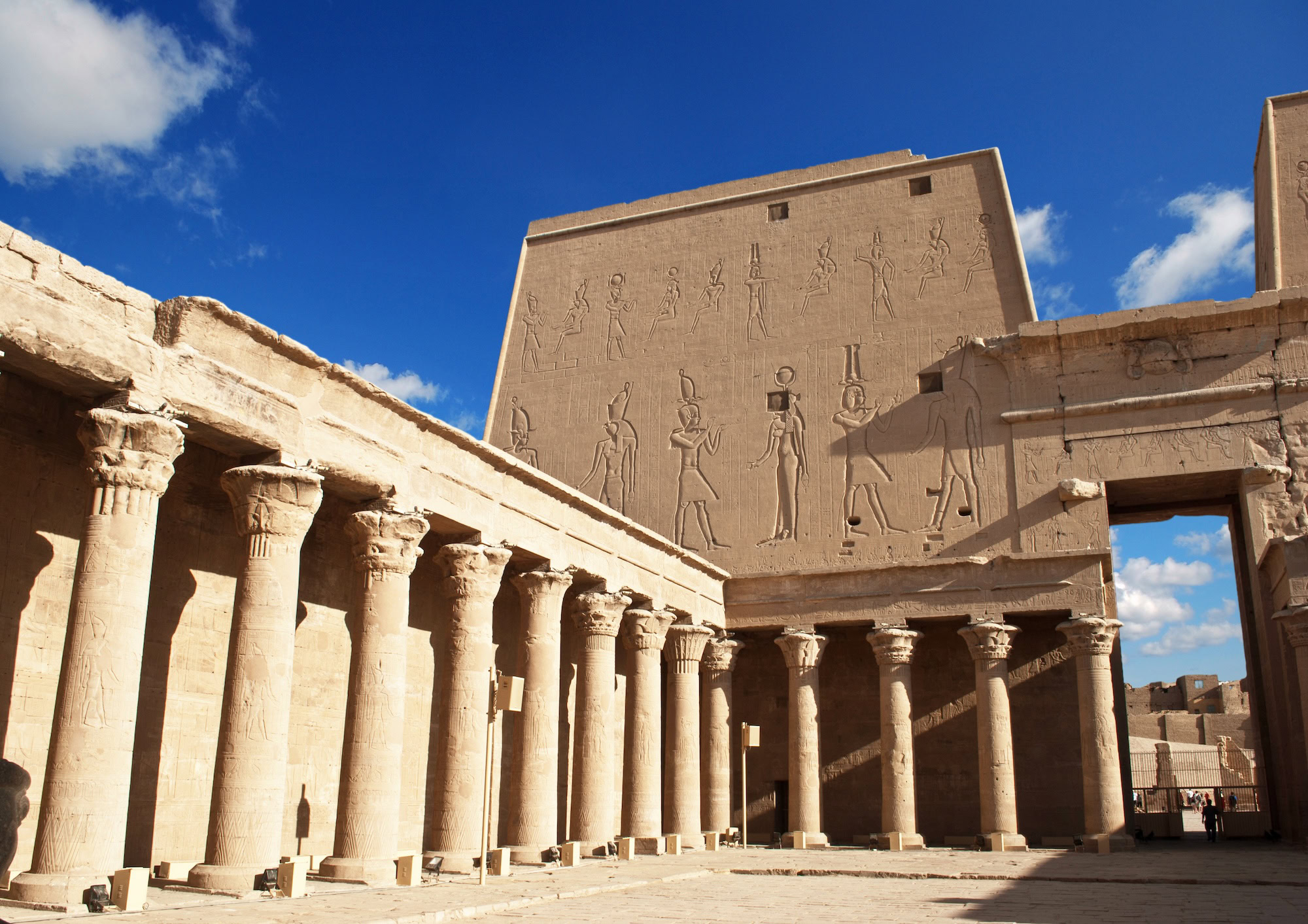 Ancient Egyptian Temple of Philae with towering columns, hieroglyphs, and open courtyard under blue sky