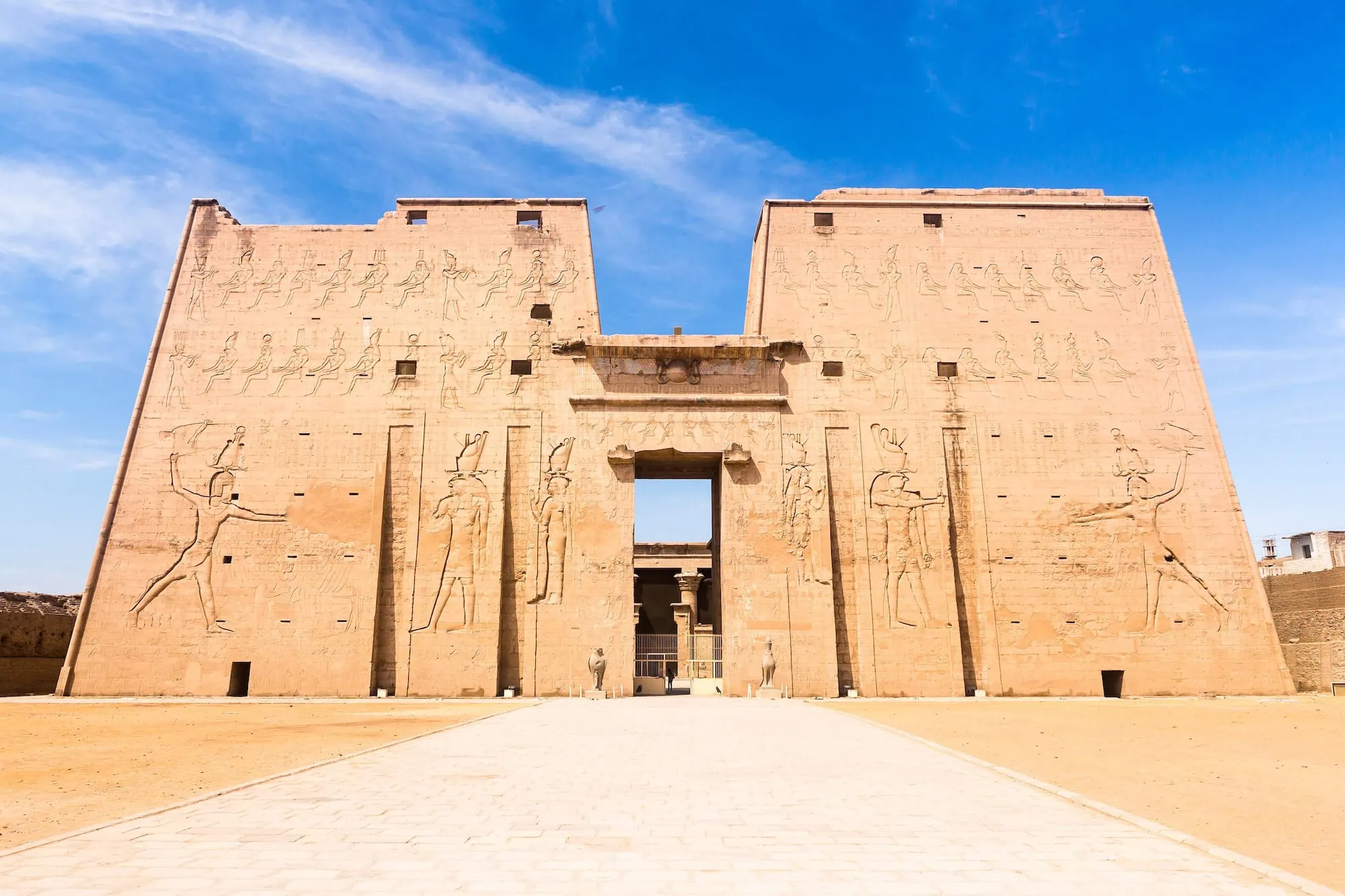 Ancient Temple of Edfu entrance with massive pylon towers and hieroglyphic carvings
