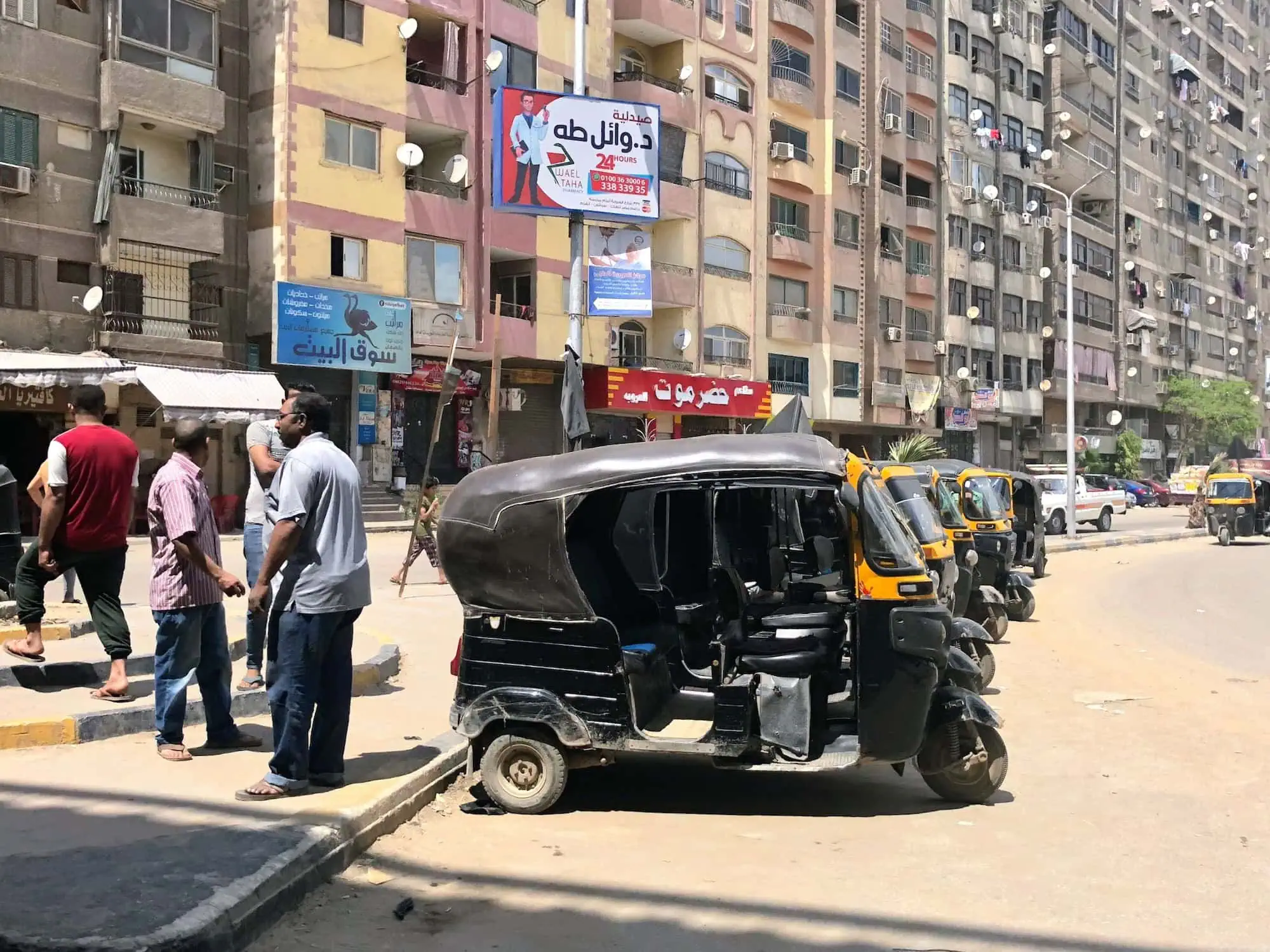 Egyptian street scene with tuk-tuk and local buildings showing everyday life