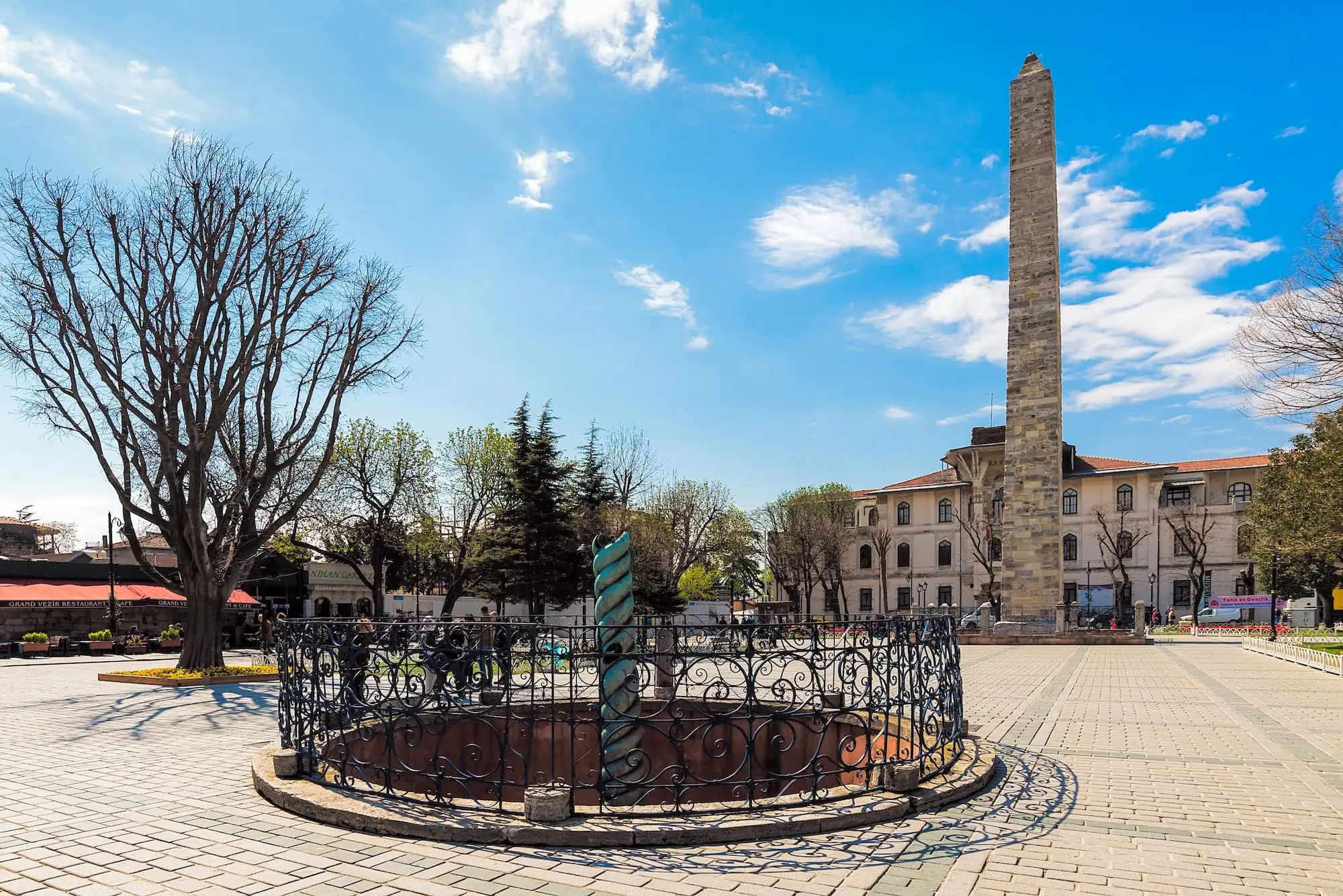 Obelisk of Theodosius in Sultanahmet square with iron fencing and historic buildings
