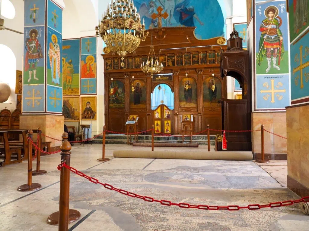 Interior view of St. George's Greek Orthodox Church showing mosaic floor and stone walls, Madaba