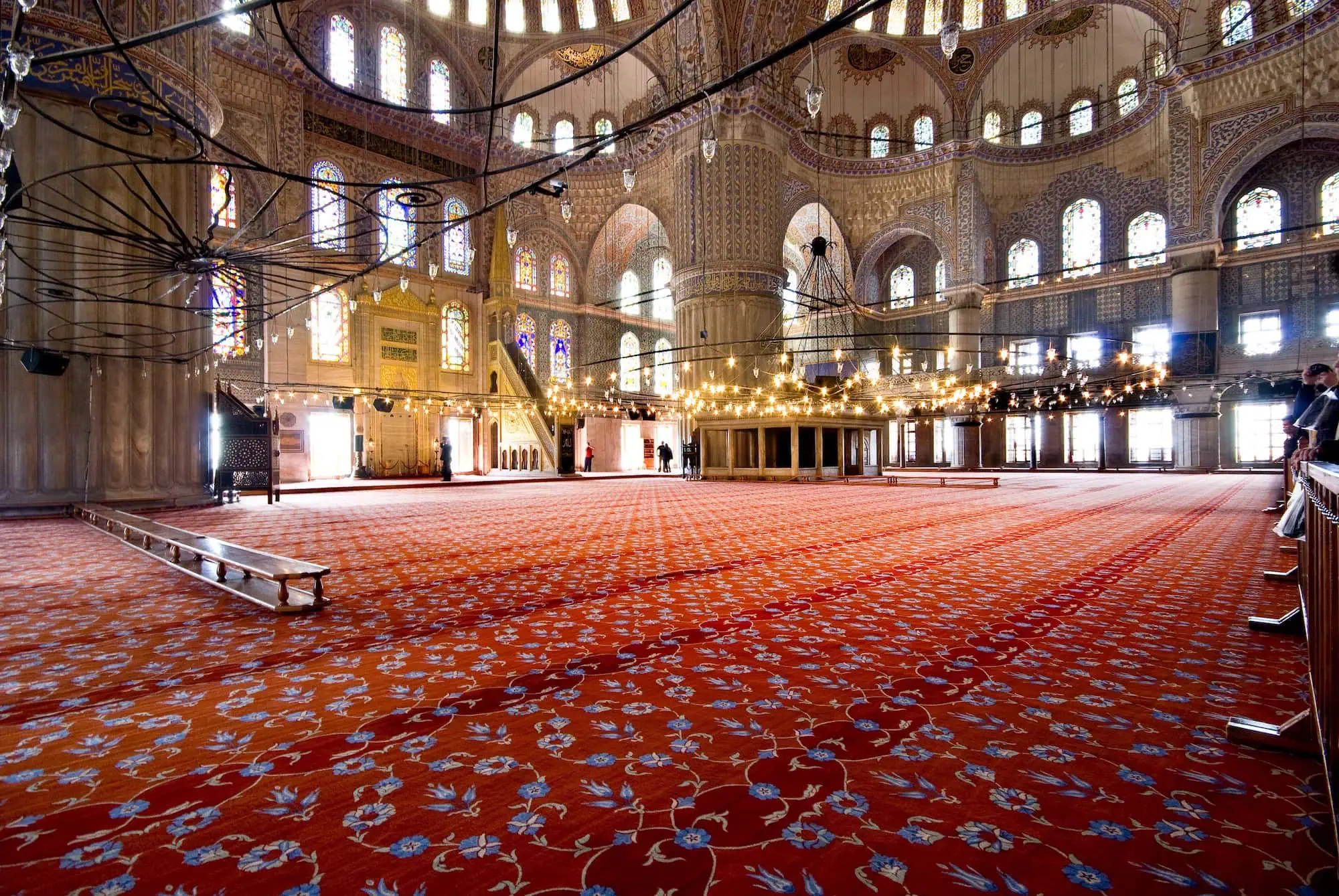Interior of Blue Mosque prayer hall with ornate blue tiles and Islamic architecture