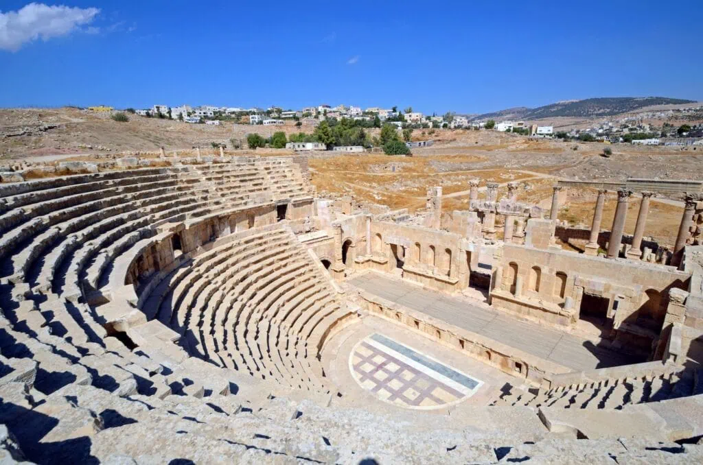 North Theater with semicircular stone seating and central stage area in Jerash
