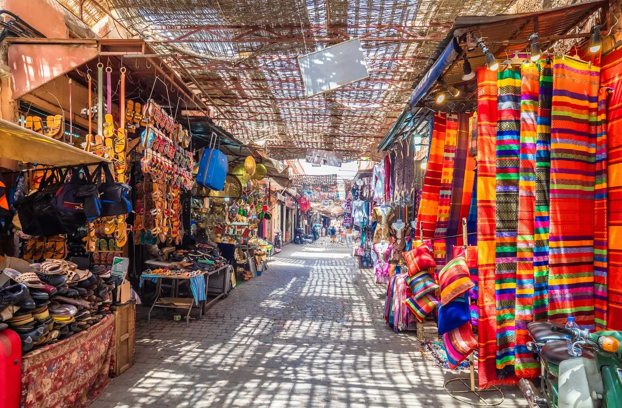 Traditional covered market souk in Marrakech with colorful textiles and souvenirs