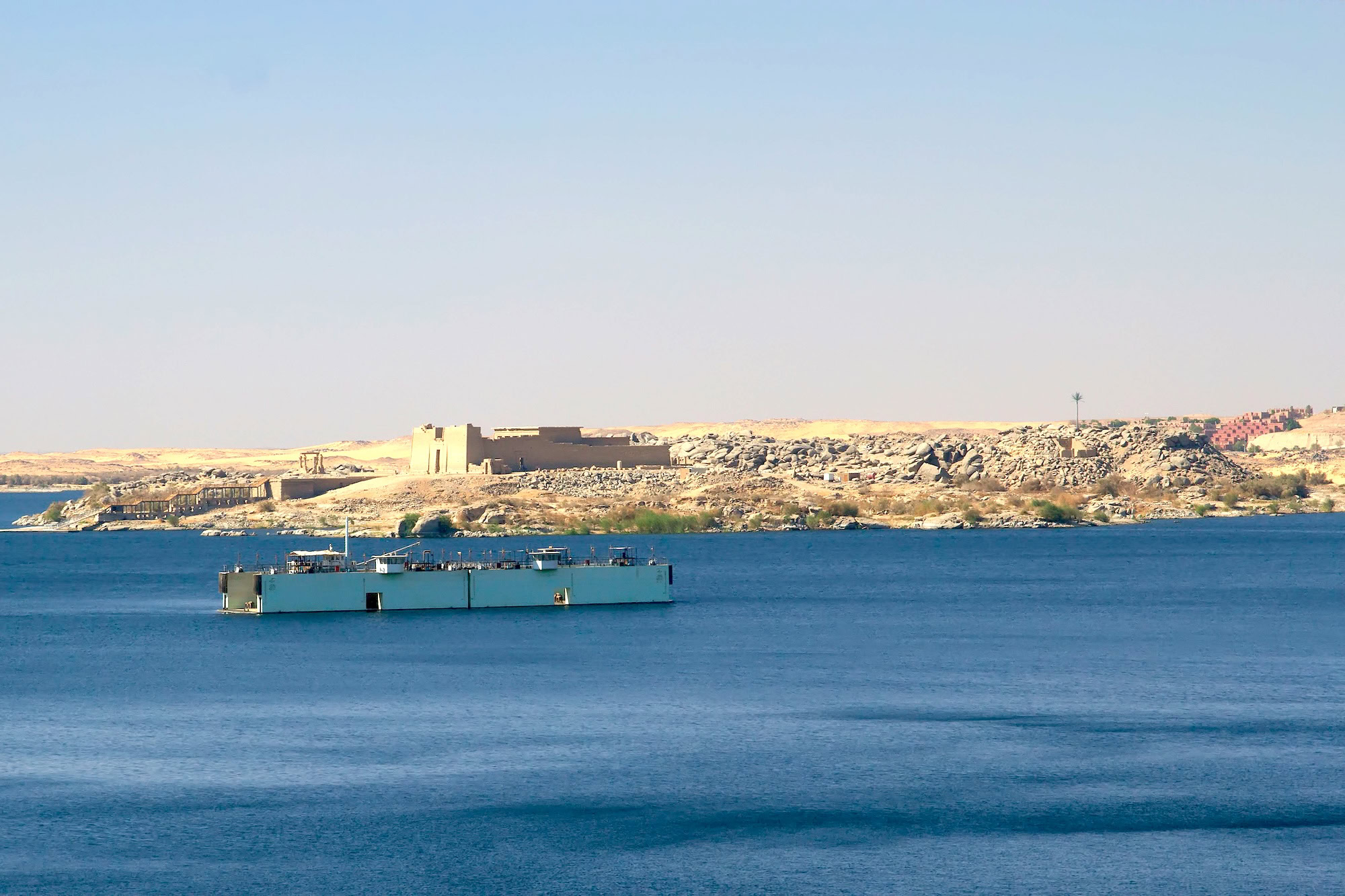 Ancient temple ruins along Lake Nasser with boat and desert landscape in Egypt