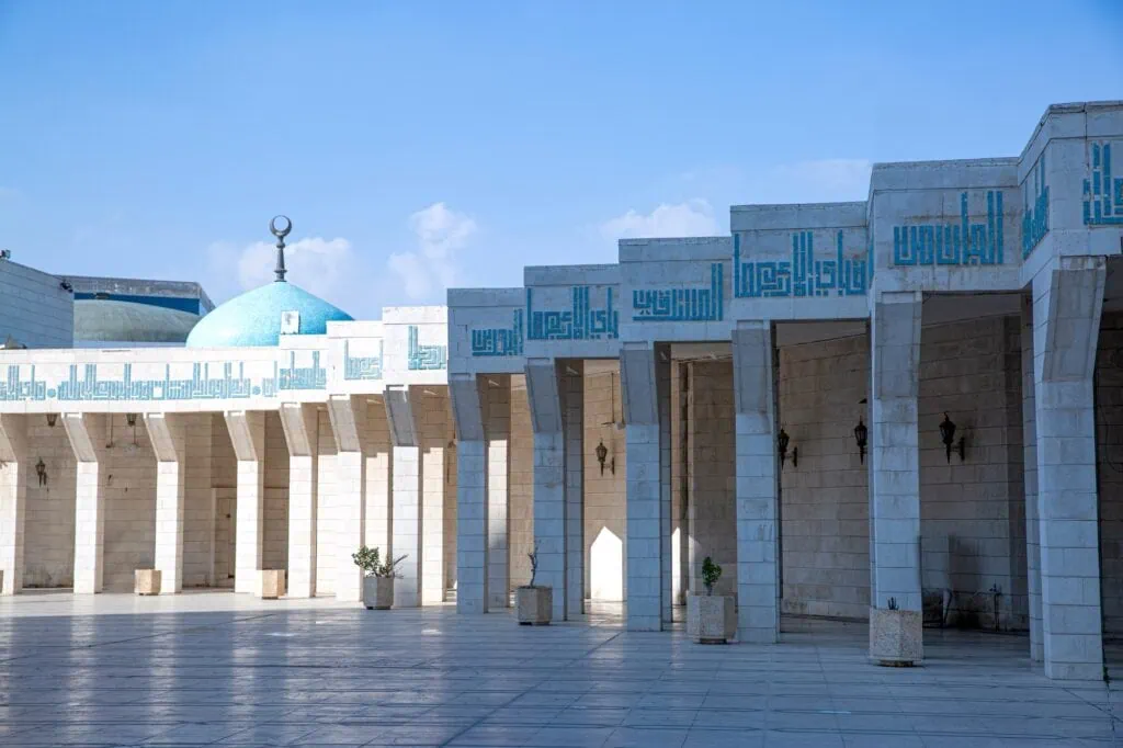 King Abdullah I Mosque courtyard with paved yard and blue-domed prayer hall Amman