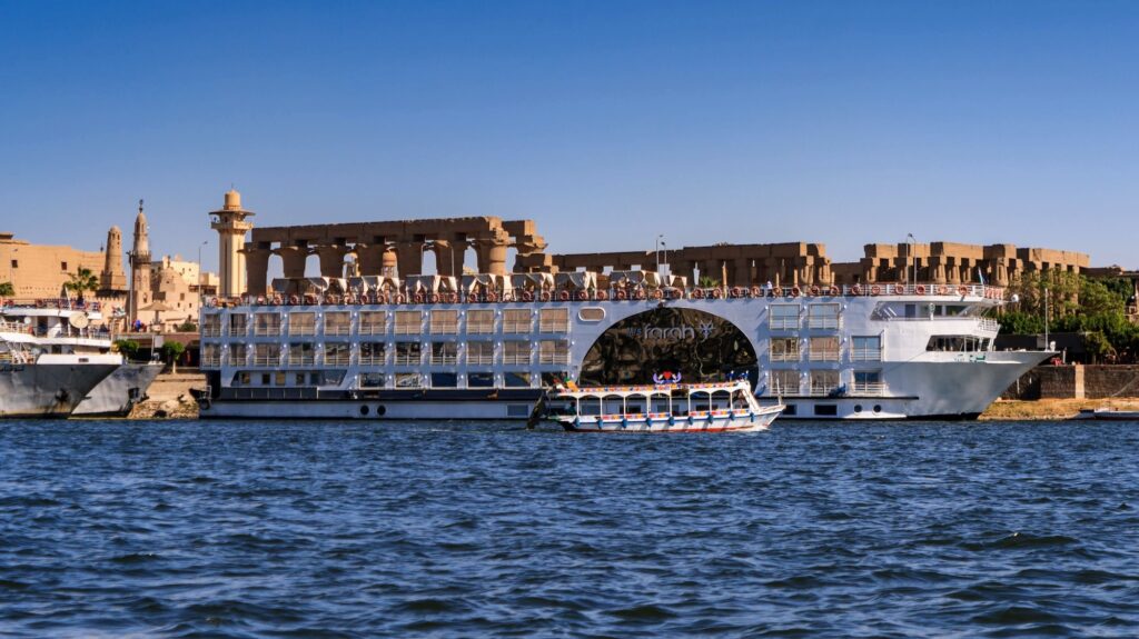 LUXOR EGYPT FEBRUARY 8 2017 Love boat passes cruise lainer Farah over the river Nile moored at the coastline