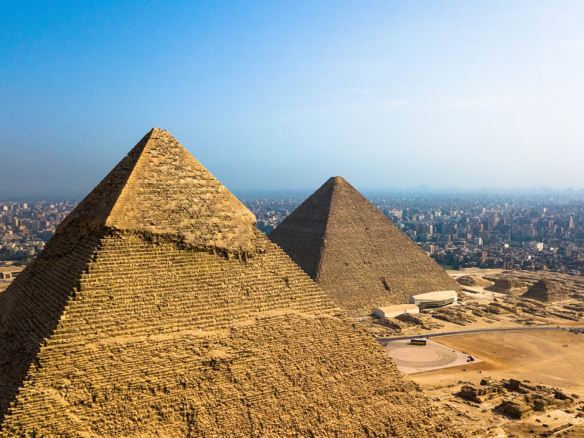 Aerial view of the Pyramids of Giza with modern Cairo city buildings in the background