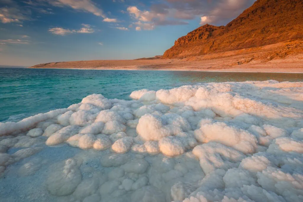 Crystalline salt formations along the shoreline of the Dead Sea between Jordan and Israel — the lowest exposed point on Earth's surface at 430 metres below sea level, with salinity around 34%, nearly ten times that of the open ocean