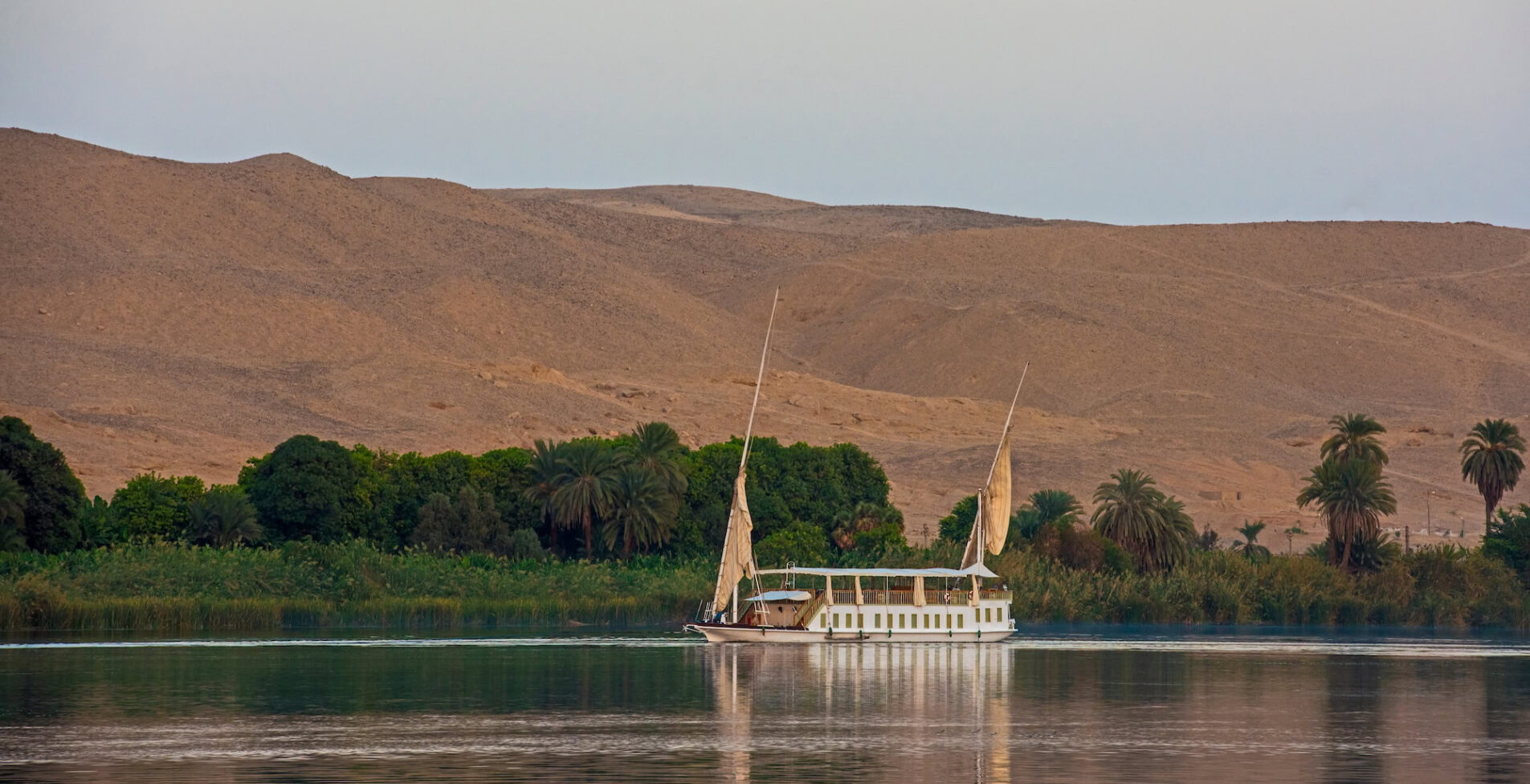Large luxury traditional Egyptian dahabeya river boat sailing on the Nile with reflection and moon in sky 1 1 1905x976 crop 50 83