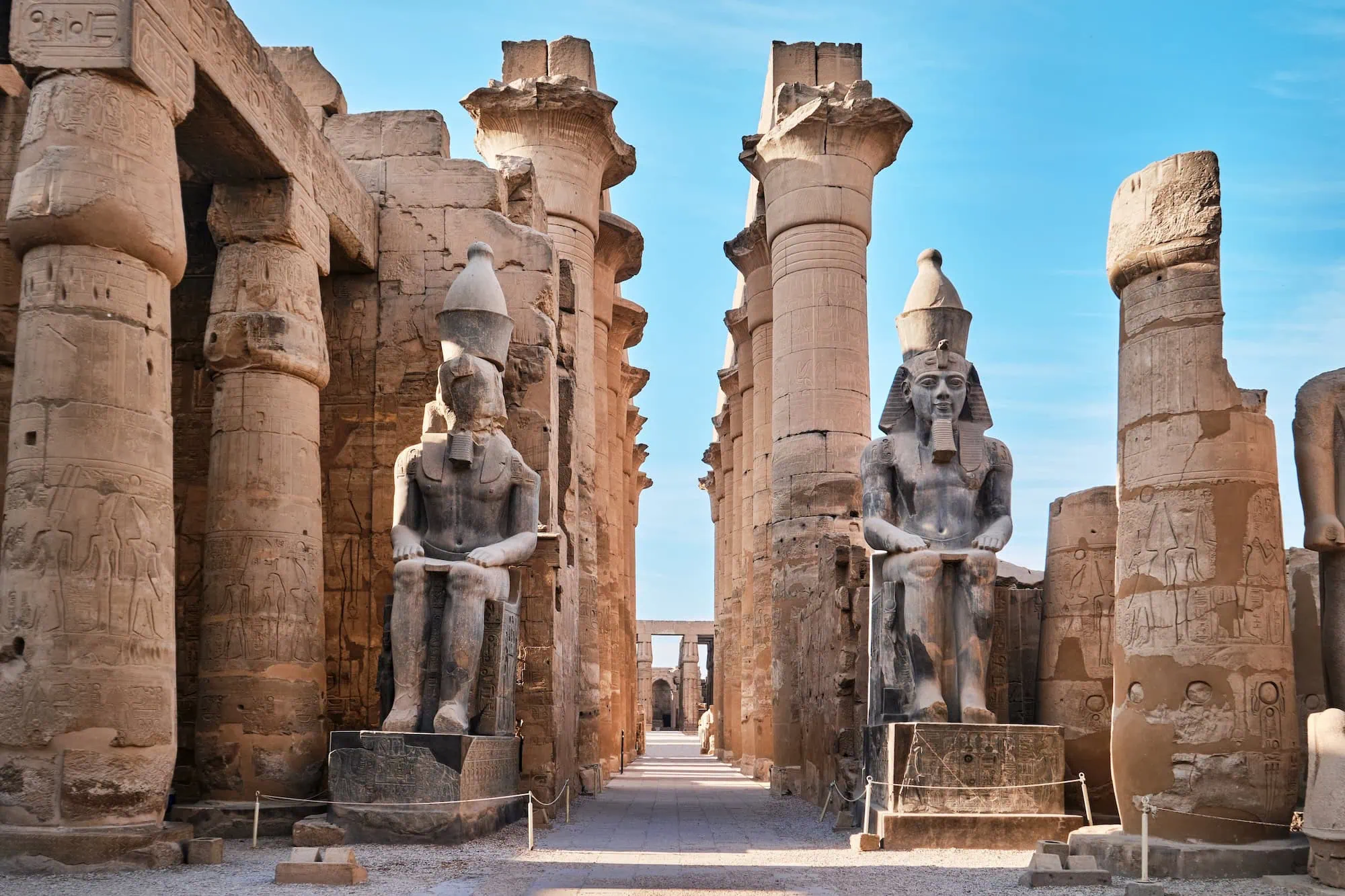 Massive stone columns and seated pharaoh statues at Luxor Temple with wide level walkways, one of the most accessible major ancient sites for senior travelers on a private Egypt tour.