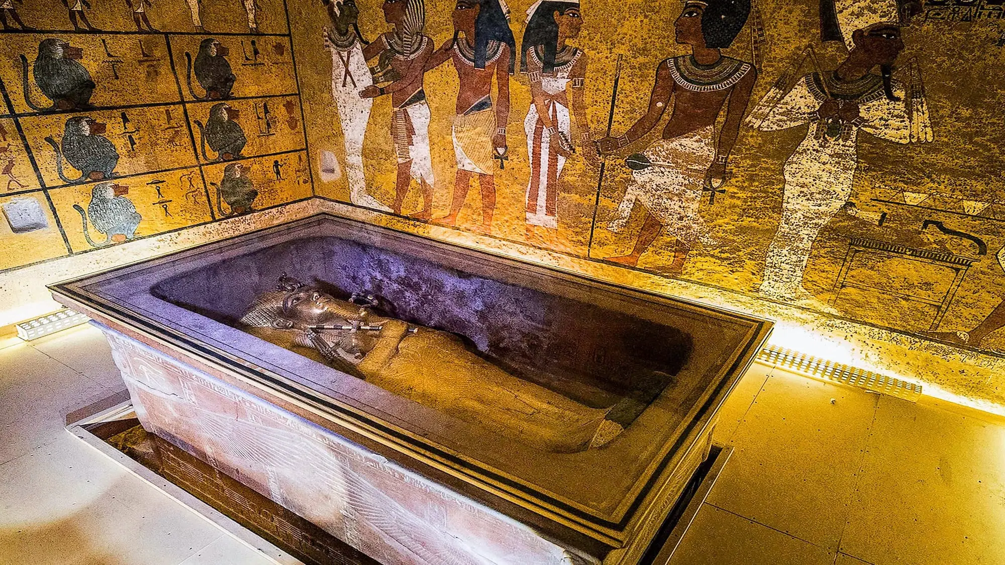 Interior of Tutankhamun's tomb showing ornate sarcophagus with hieroglyphic wall paintings