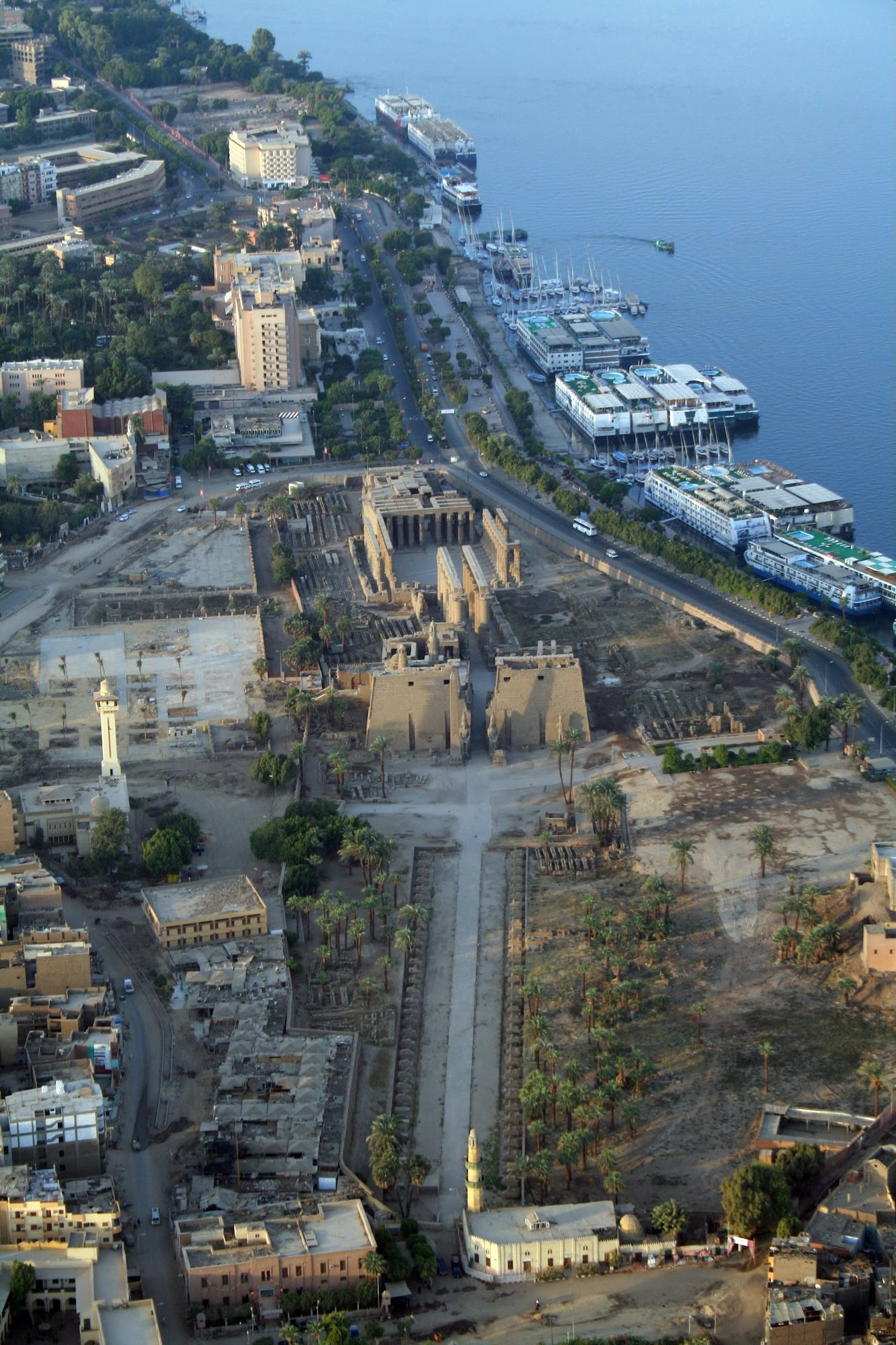 Aerial view of Luxor Temple with Nile River cruise ships and boats docked nearby