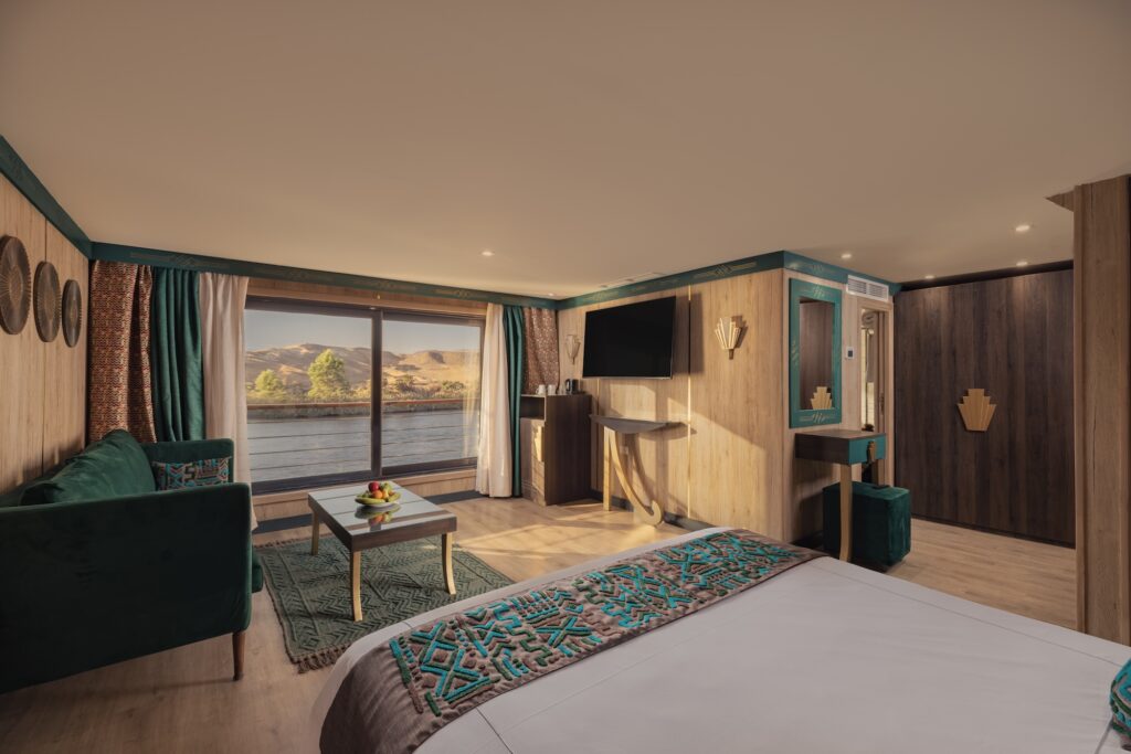 Elegant Nile cruise suite with plush bed, seating area, and large river-view windows