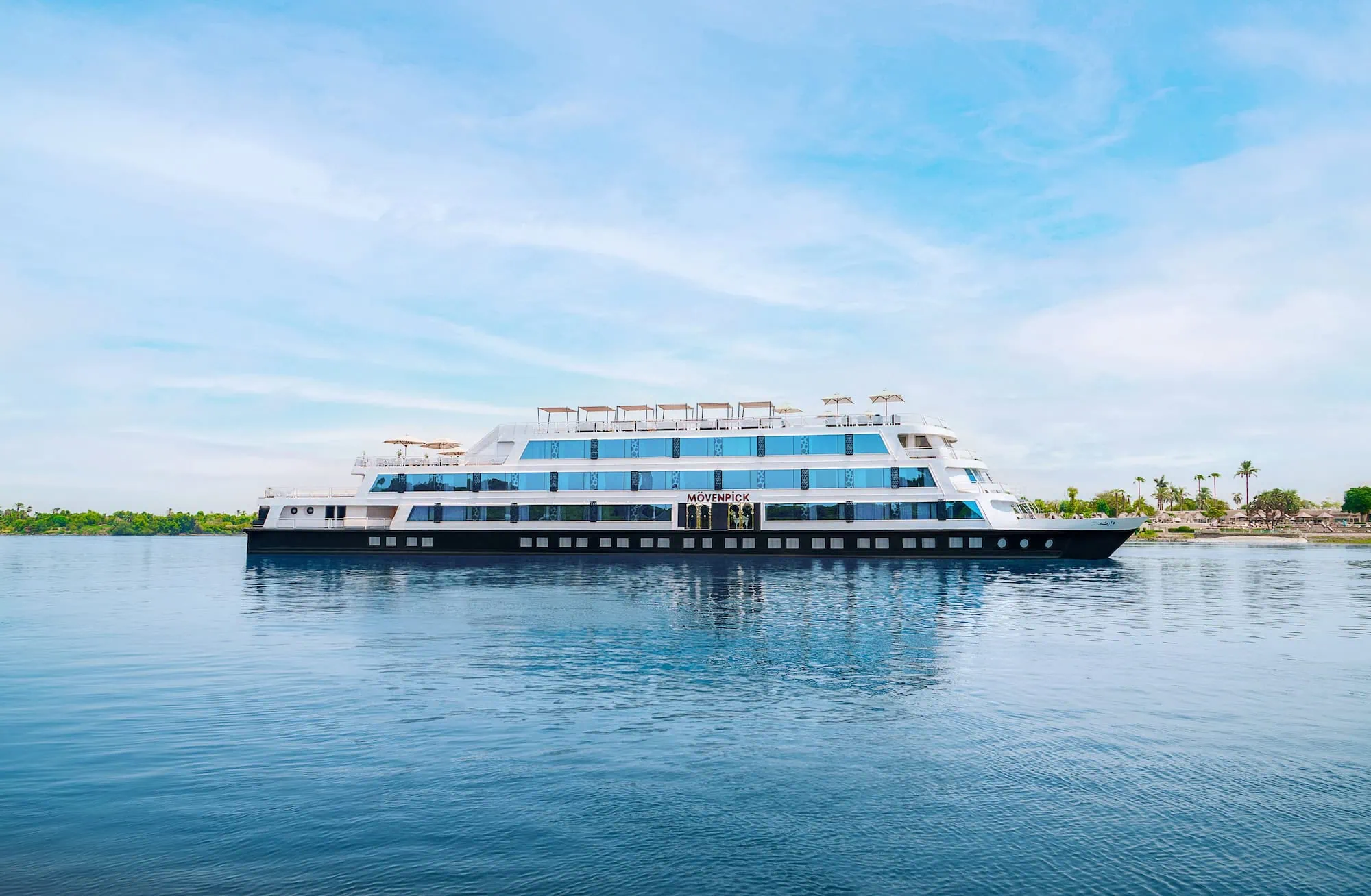 Modern white cruise ship sailing on the Nile River in Egypt