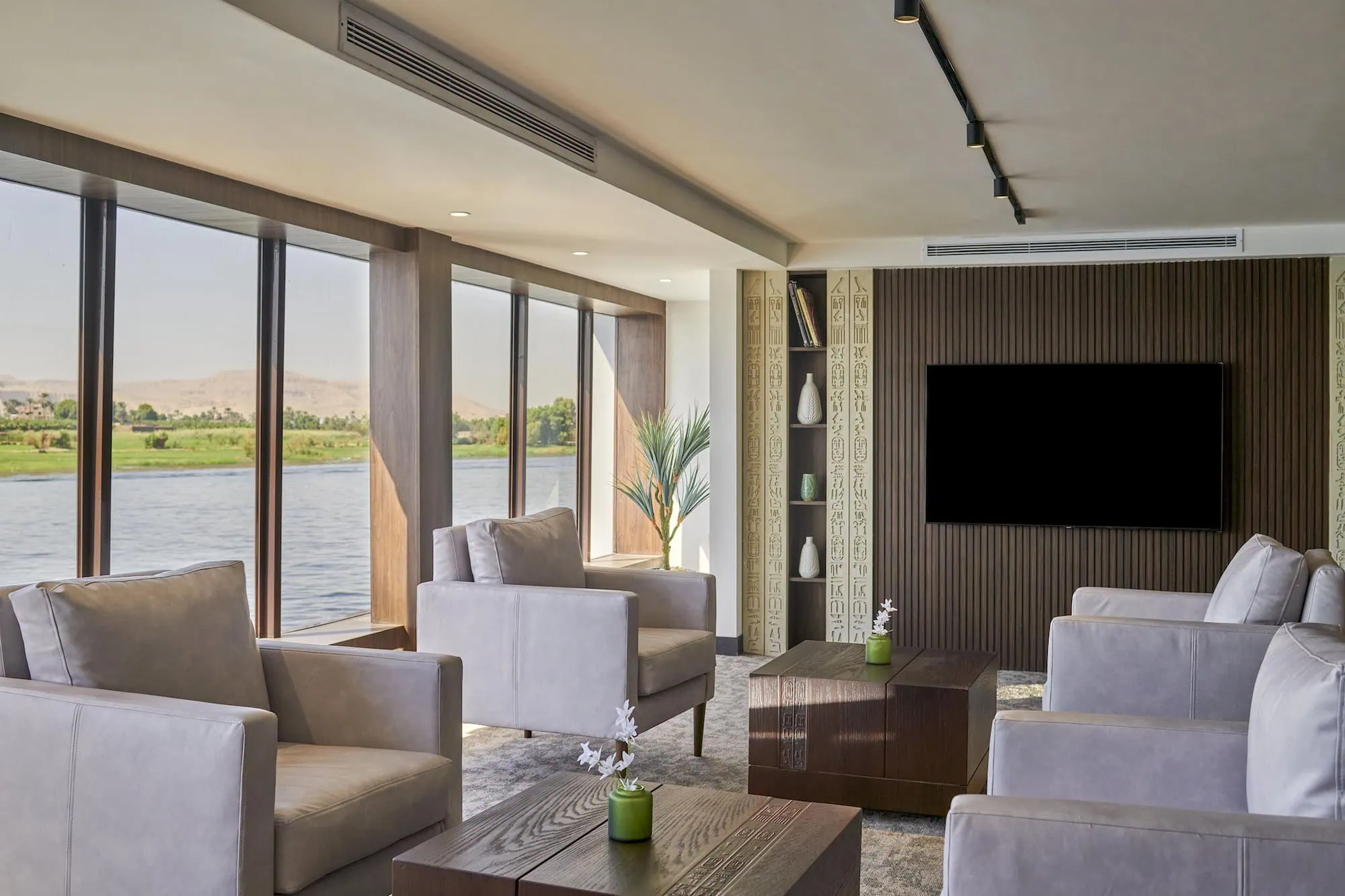 Luxurious cruise ship lounge with elegant armchairs and panoramic Nile River views