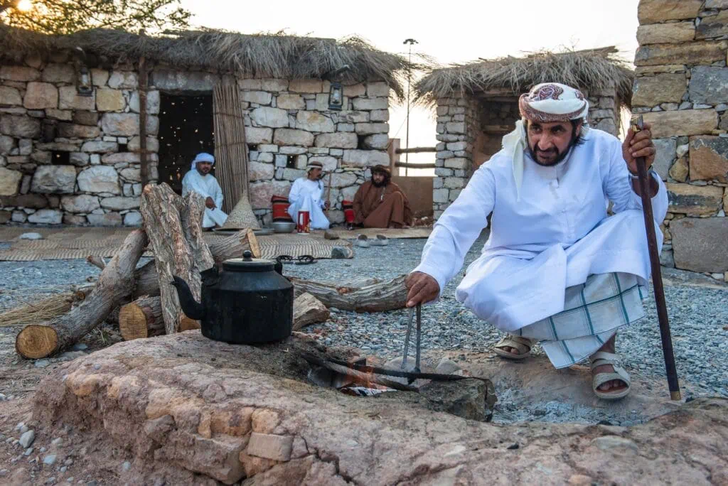 Man lighting a fire during traditional activity demonstration at Heritage Village Dubai
