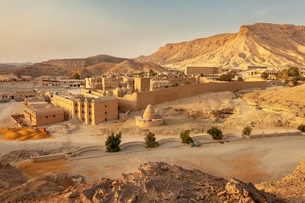 Stone buildings and fortified walls of the Monastery of Saint Paul the Anchorite set against the Eastern Desert mountains in Red Sea Governorate