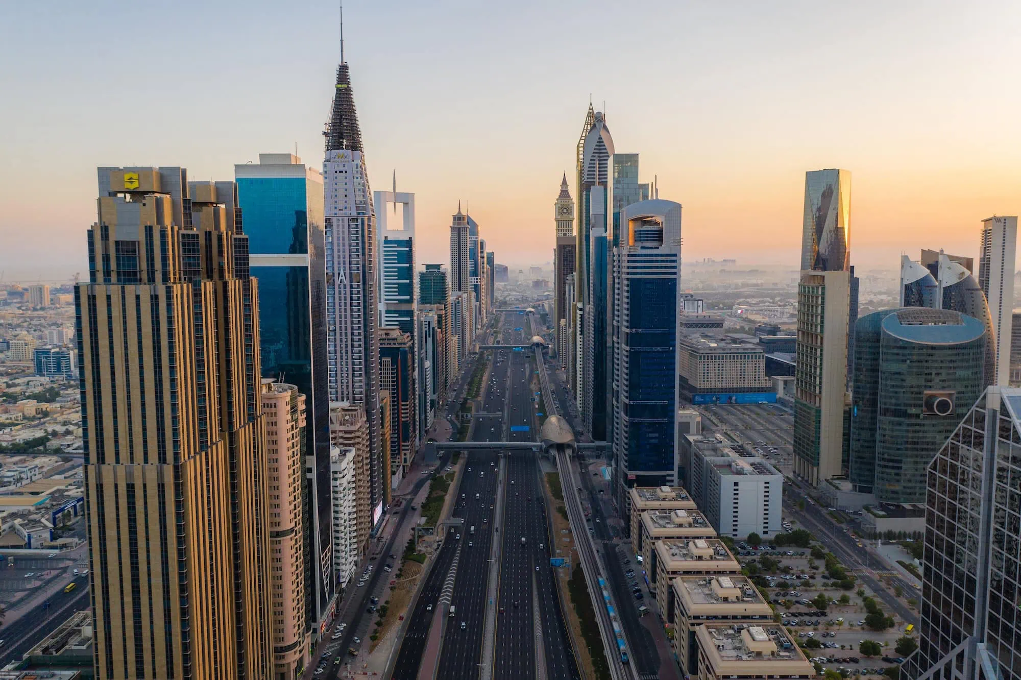 Aerial view of Sheikh Zayed Road in Dubai during sunrise showing modern skyscrapers and highway traffic