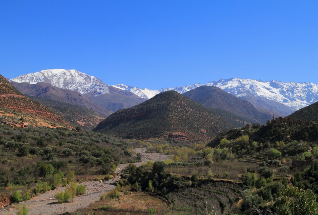 High Atlas Mountains landscape with snow-covered peaks of Toubkal National Park overlooking a river valley near Asni Marrakech
