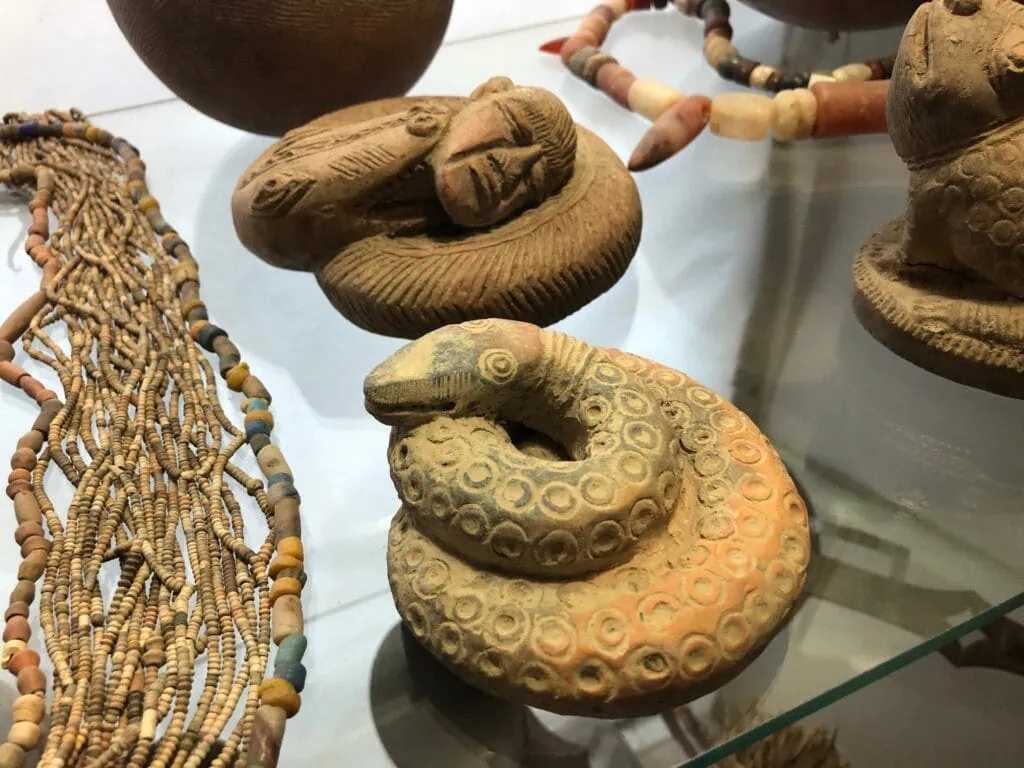 Musée Bert-Flint display of carved figurines and beaded jewelry arranged in a glass case Marrakech