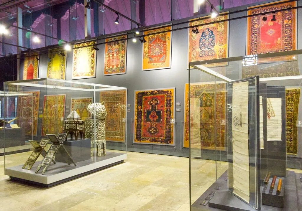 Wall-mounted carpets and glass display cases with decorative objects in the Islamic Arts Museum Istanbul