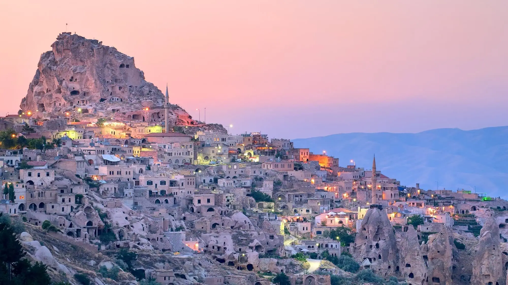 Historic cave city of Nevşehir in Cappadocia with stone buildings carved into volcanic rock formations