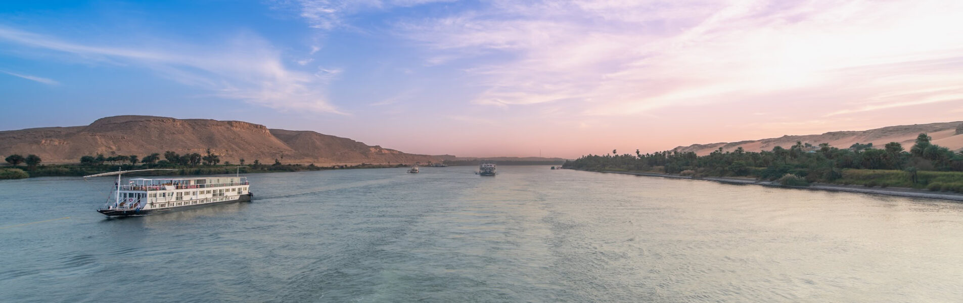 Nile River near Esna Lock in Aswan, Egypt, as two cruise boats navigate the waters