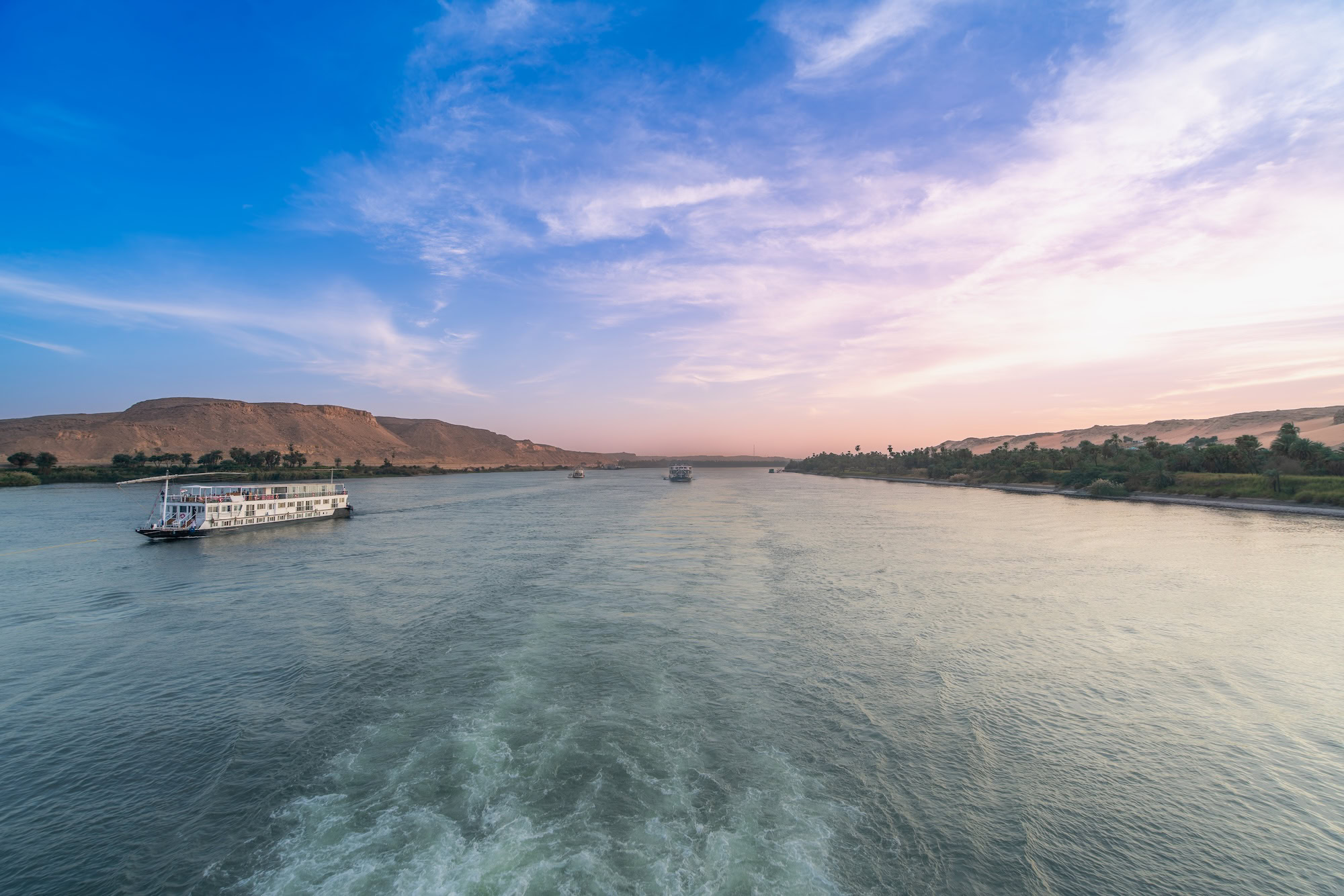 Nile River near Esna Lock in Aswan, Egypt, as two cruise boats navigate the waters