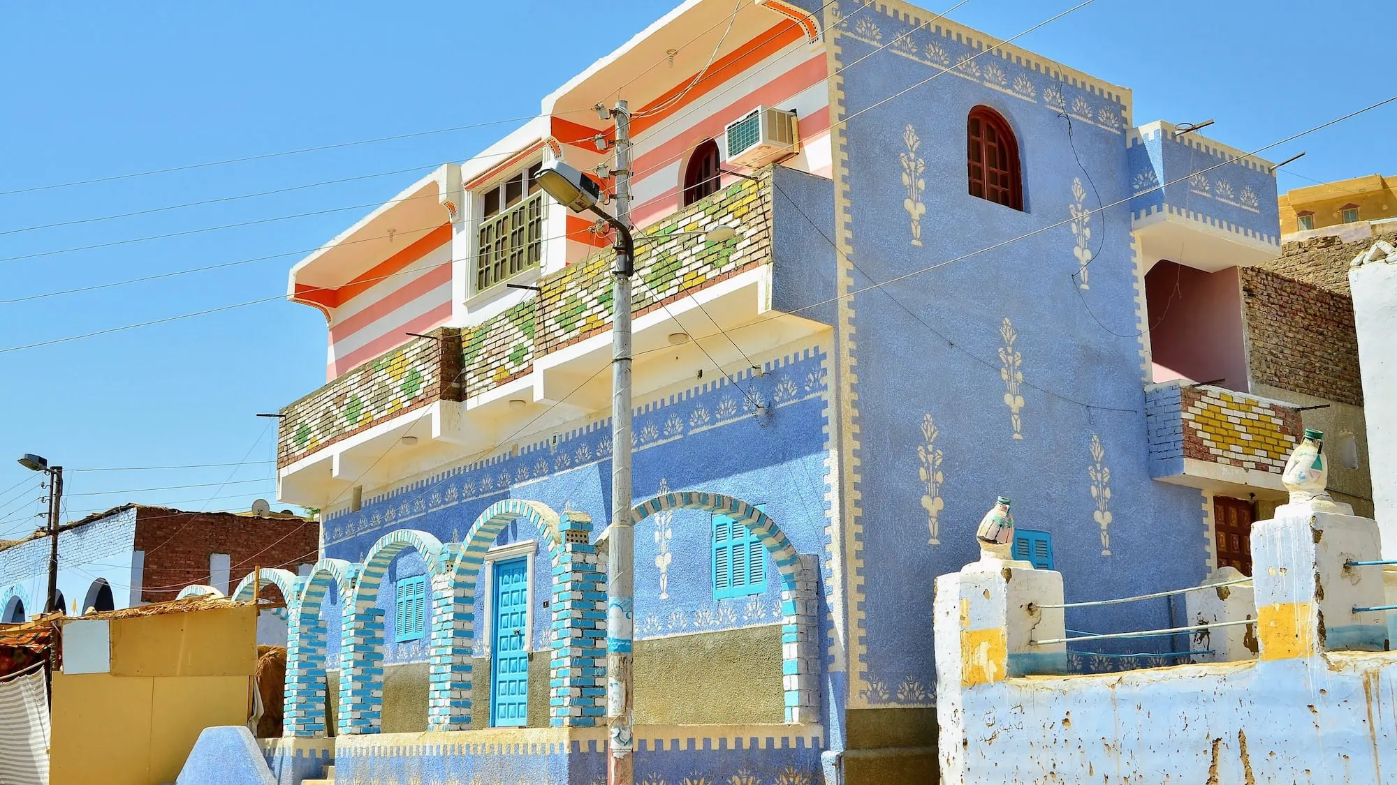 A colourful Nubian village building with decorative painted patterns and traditional architecture near Aswan, Egypt.