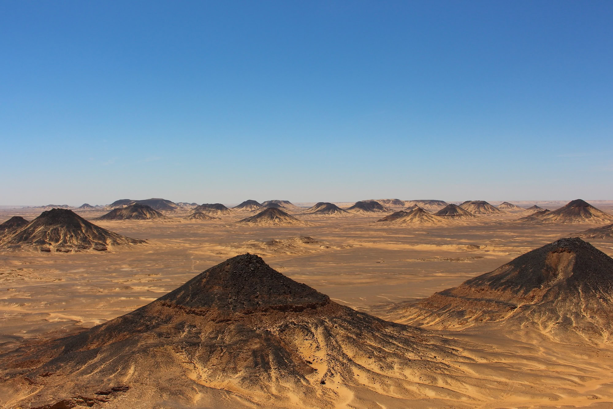 Volcanic hills and rocky formations in Egypt's Black Desert landscape