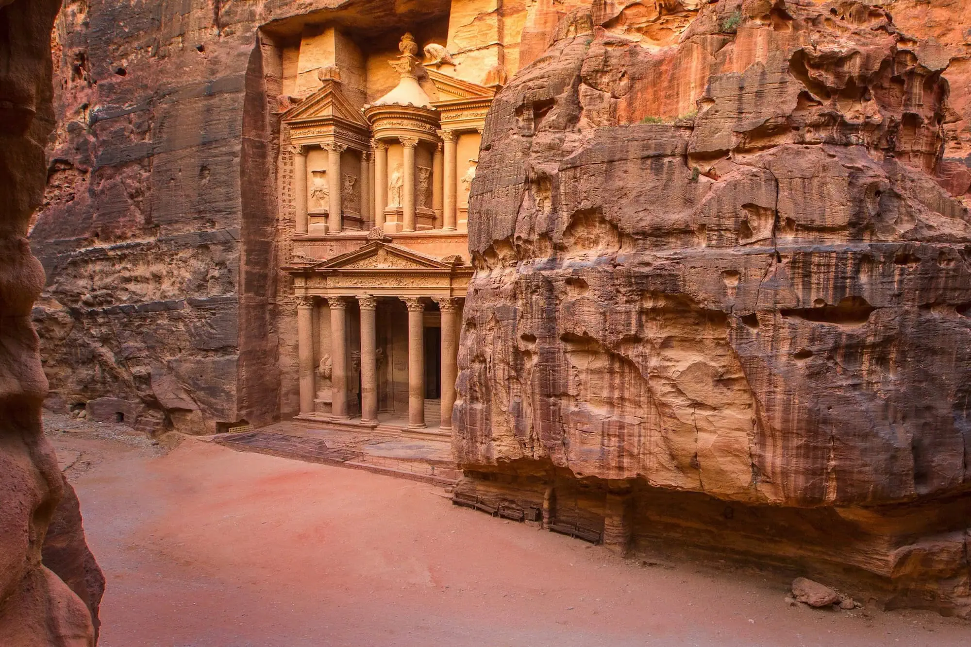 The iconic Treasury (Al-Khazneh) facade carved into rose-colored sandstone cliffs at Petra archaeological site