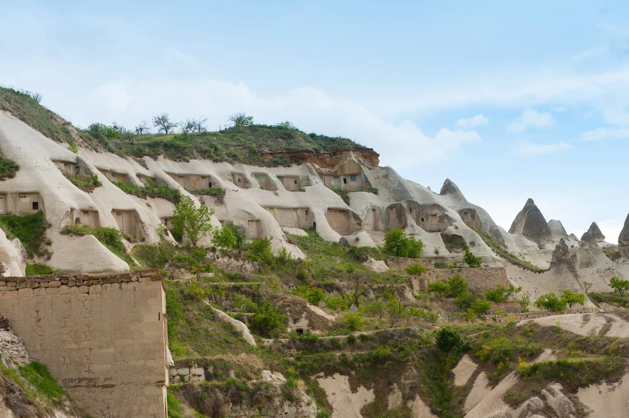 Ancient pigeon houses carved into white volcanic rock cliffs in Cappadocia