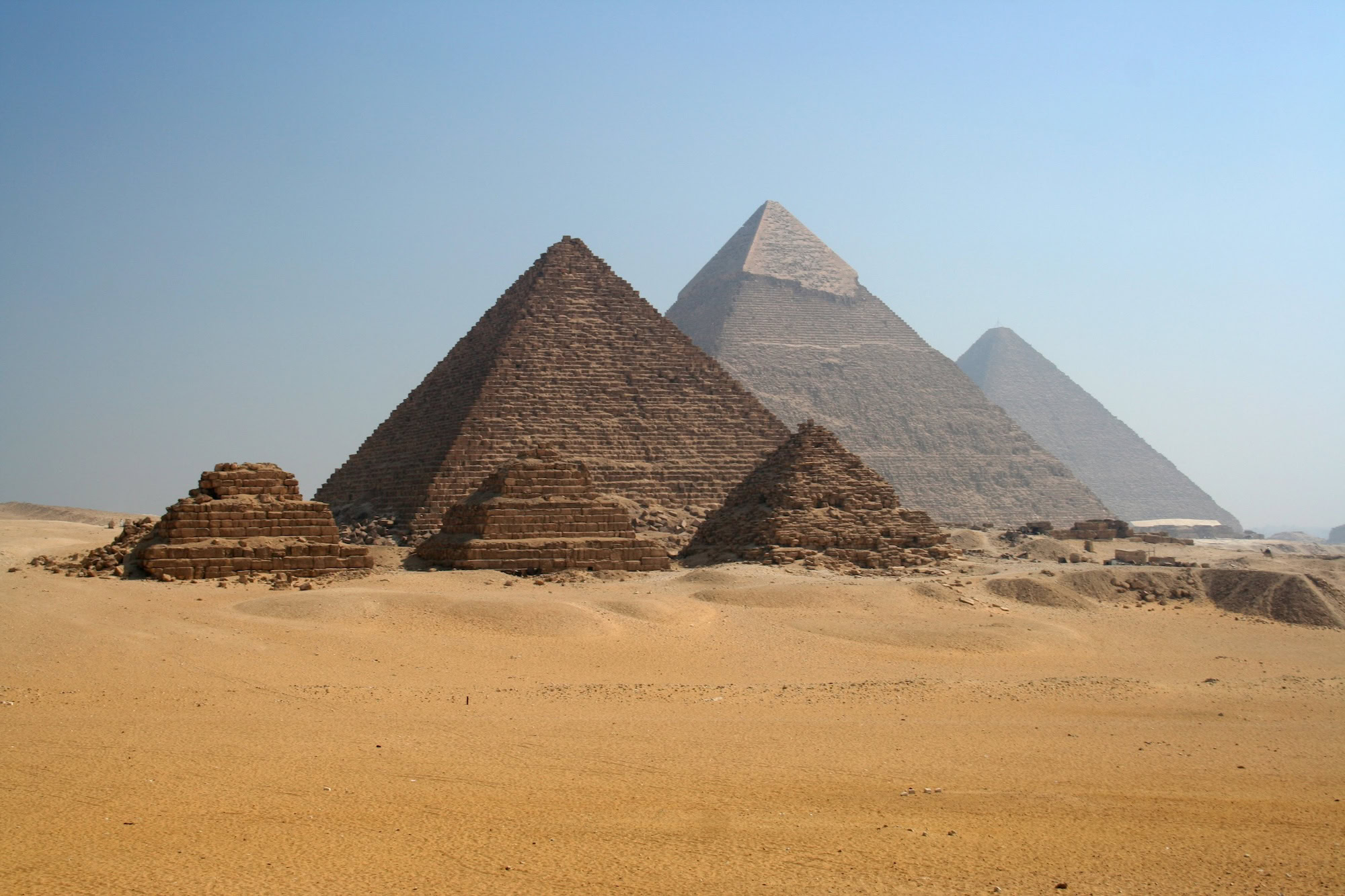 Ancient pyramids of Giza with stone blocks in desert landscape