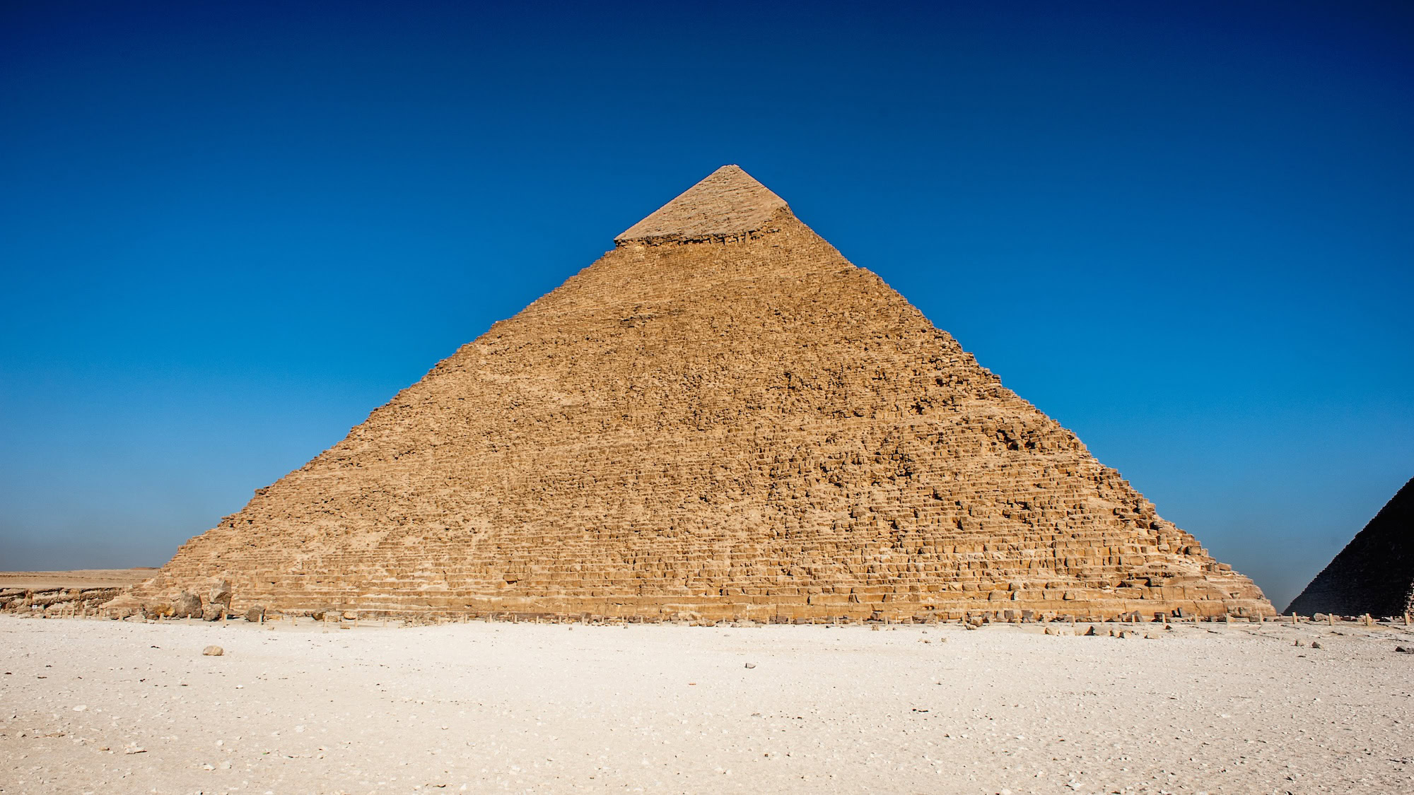 Pirámide de Kefrén vista desde abajo mostrando su imponente altura contra el cielo claro