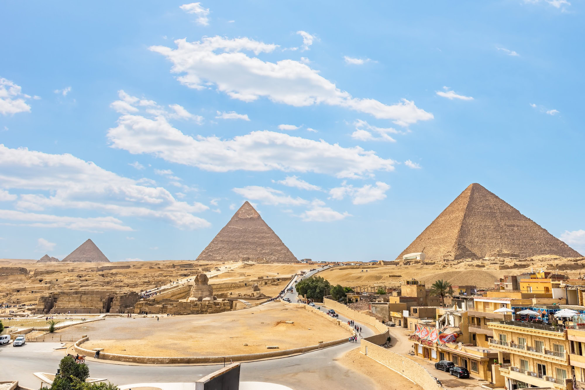 Great Pyramids of Giza and Sphinx with tourists and vehicles showing busy high season