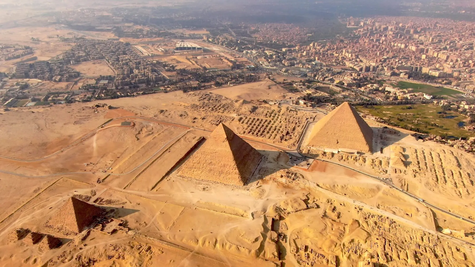 Aerial view of the three Pyramids of Giza, with the smaller queens' pyramids alongside, on the desert plateau at the edge of Cairo, Egypt. 5-day Egypt tours.