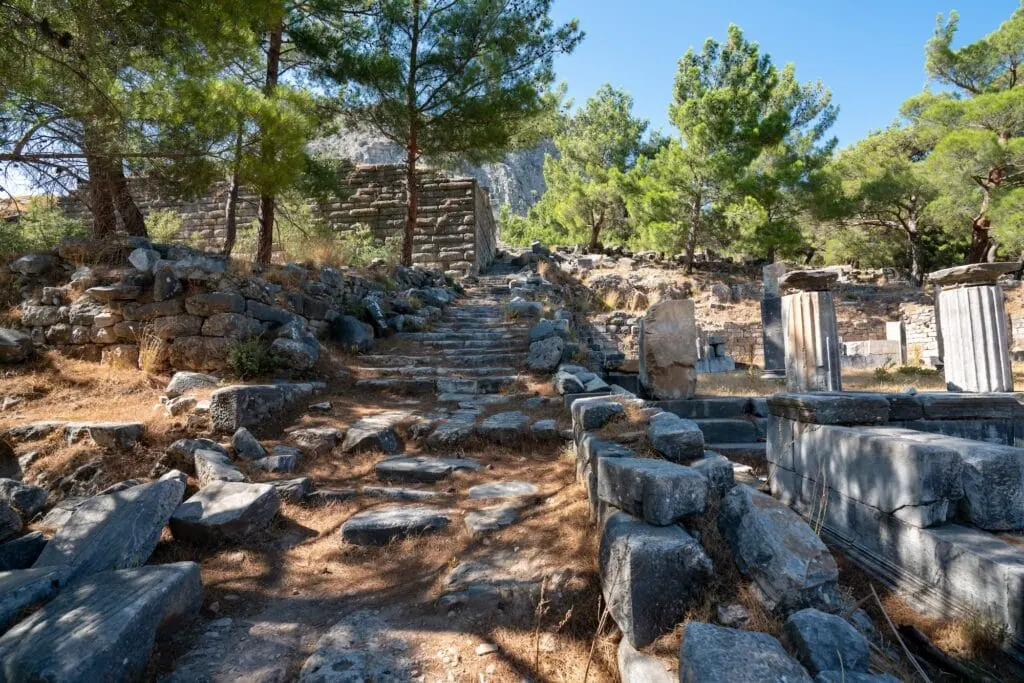 Grid-planned stone streets, theater seating, and temple ruins on a hillside at Priene Ancient City, Aydın
