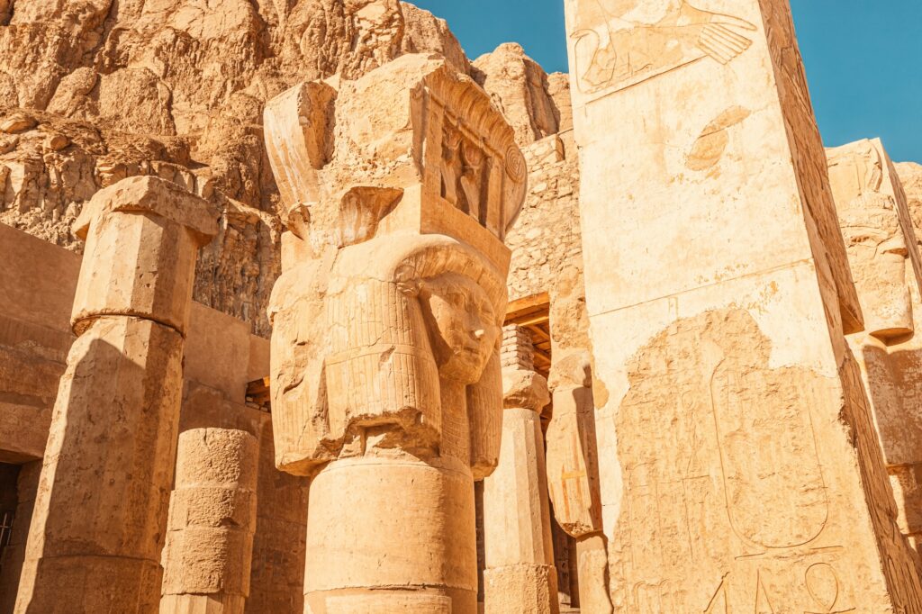 Ruined columns and a carved pharaoh face within the Temple of Hatshepsut at Deir el-Bahari, Luxor