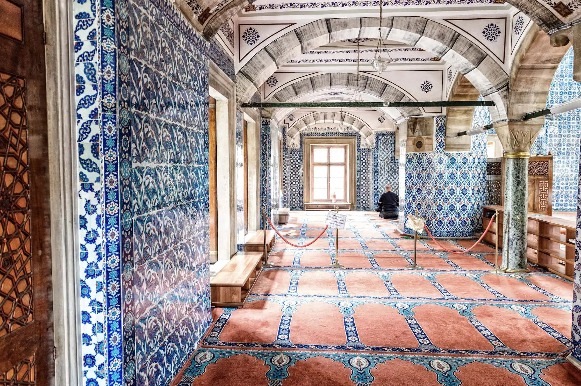 Interior of Rustem Pasha Mosque showing ornate blue and white Islamic tile work and Ottoman architecture