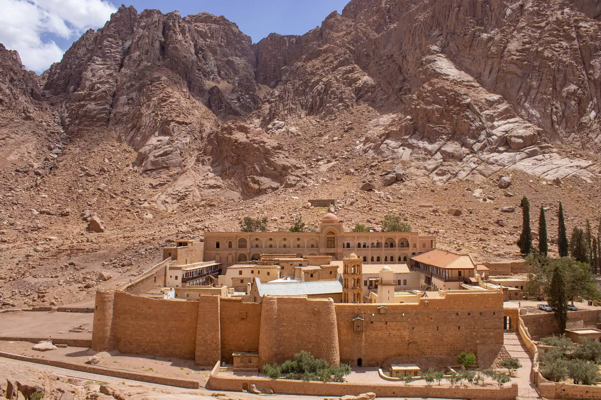 Saint Catherine's monastery with stone buildings and walls at the base of Mount Sinai's rocky cliffs