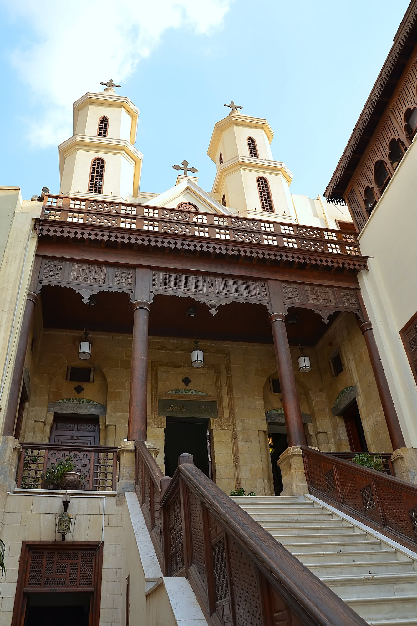 Historic Coptic Orthodox Church with wooden balcony, stone stairs and traditional architectural elements