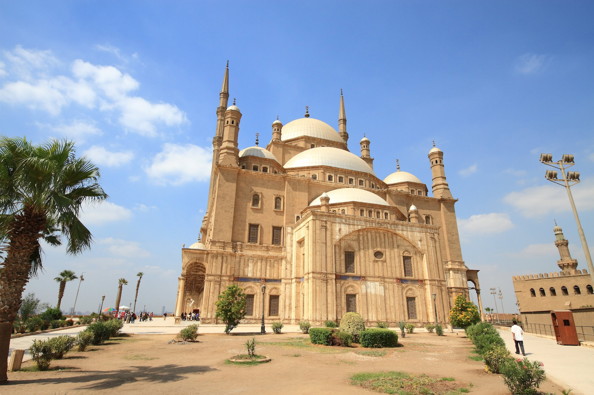 Tourists visiting the Mosque of Muhammad Ali in Cairo with domes and minarets visible