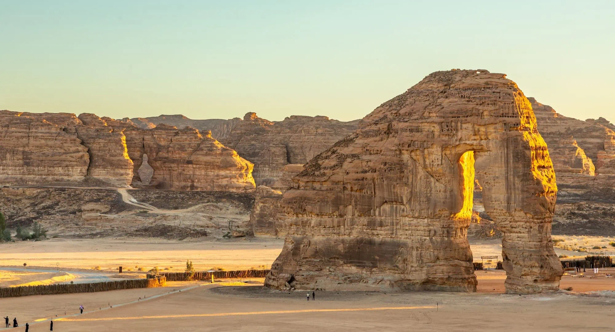 Elephant Rock sandstone formation in AlUla desert with visitors on pathway